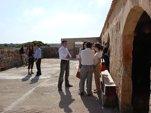 a group of people standing around next to a stone building