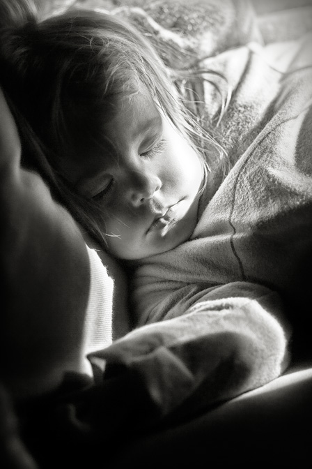 a little girl that is sleeping on a bed