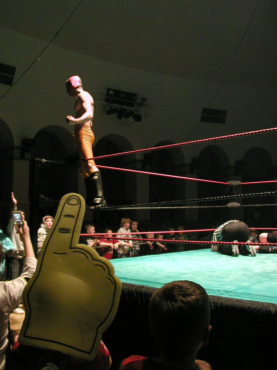 a wrestler standing on top of his hand in a stadium
