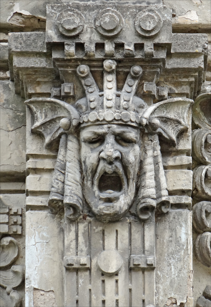 a statue with an elaborate head, surrounded by gargoyles