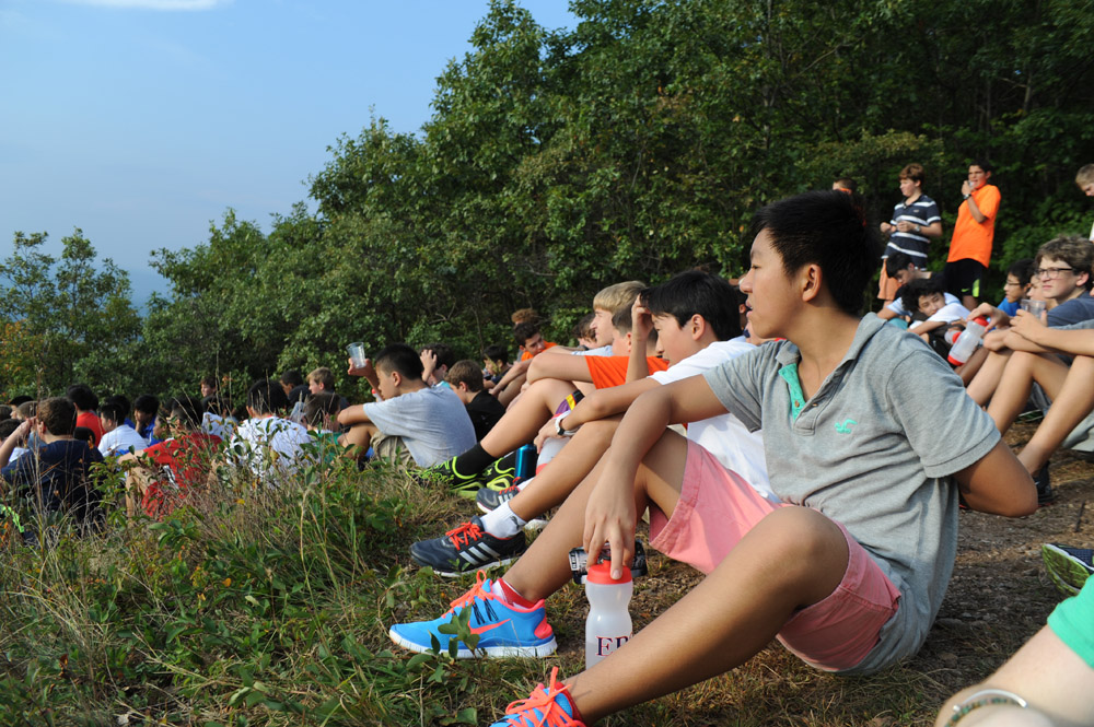 a group of young people sitting on a park bench with frisbees