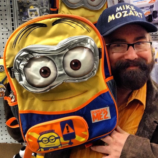 a man with glasses is holding a backpack