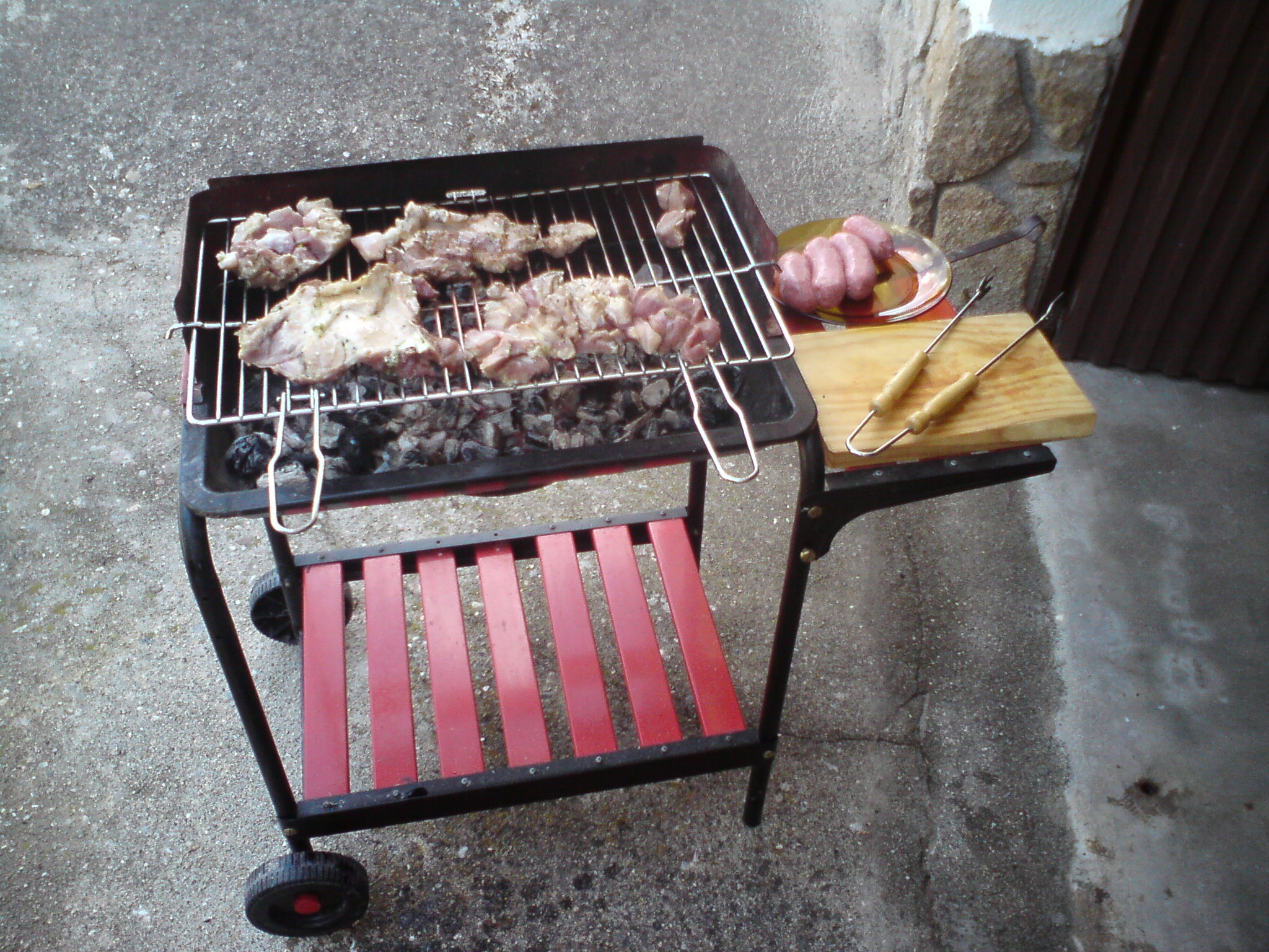 a man grilling meat on the grill