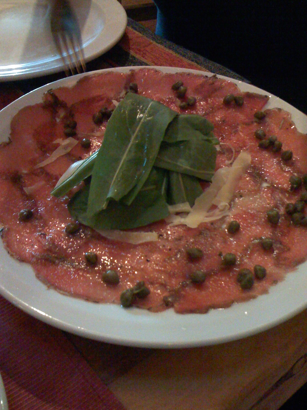 a white plate topped with green vegetables on a table