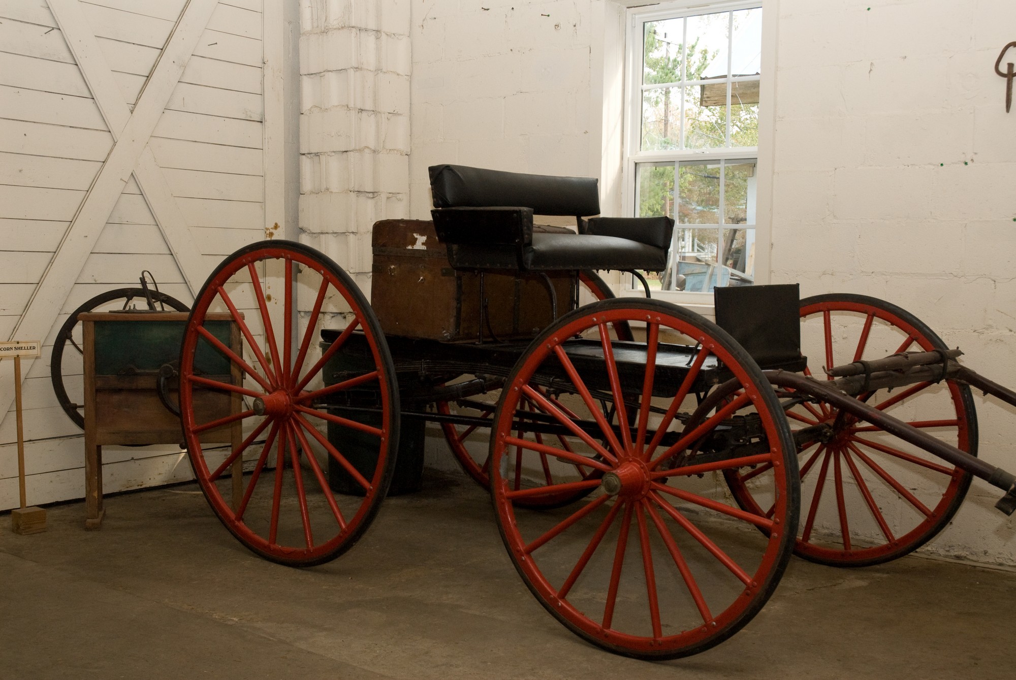 a very nice old horse drawn buggy in a big room