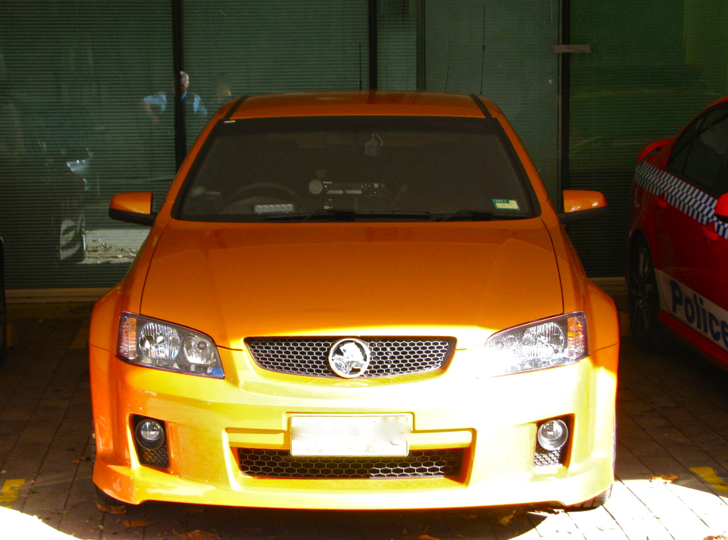 a yellow car and a red car on a driveway