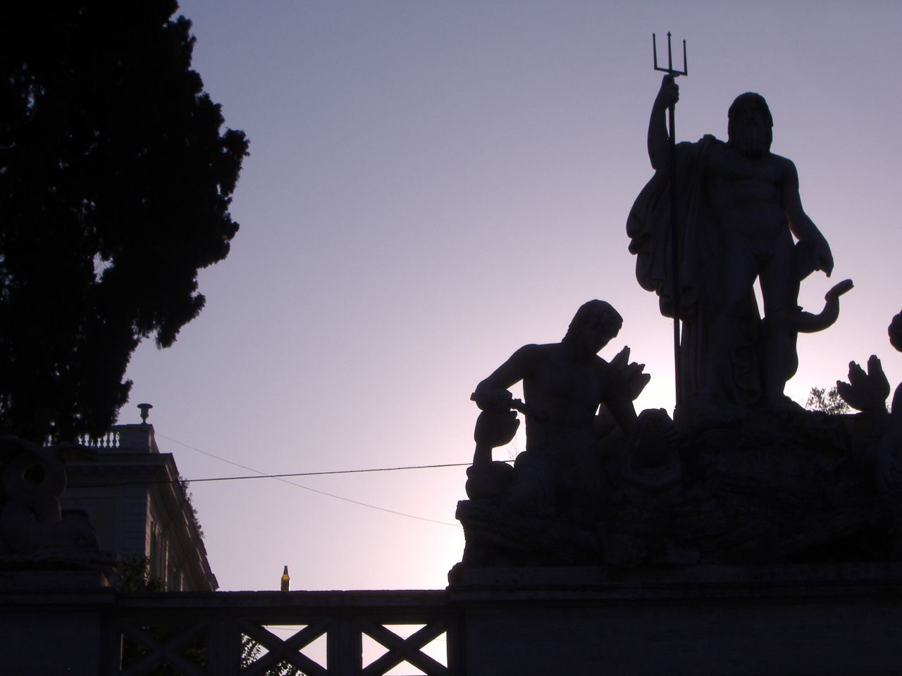 a statue in front of the sun on a clear day