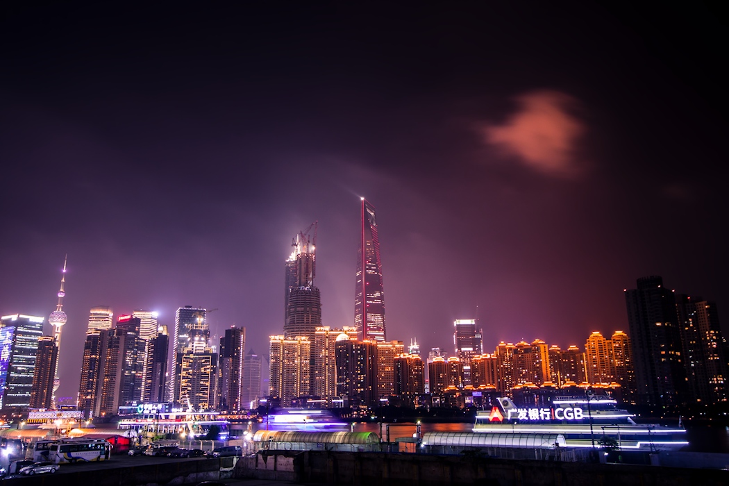 a big city skyline at night time with a few cars