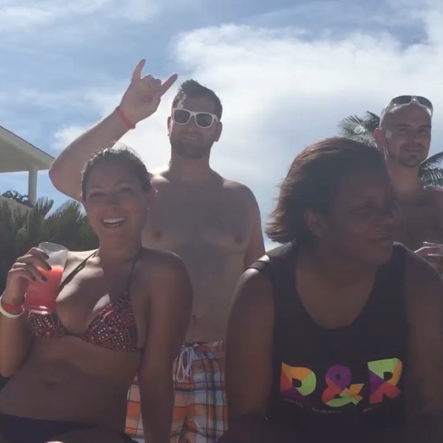 a group of people standing around a pool smiling