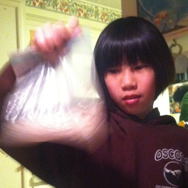 an asian woman holding up a bag with soing in it