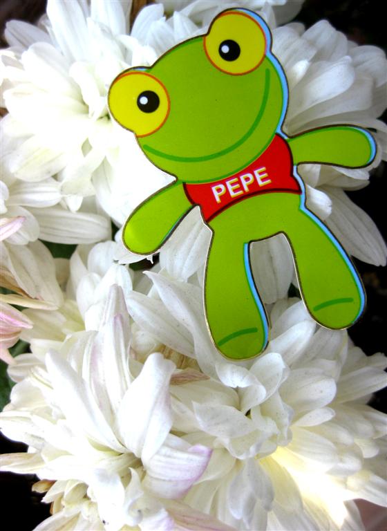 a green stuffed animal on top of white flowers