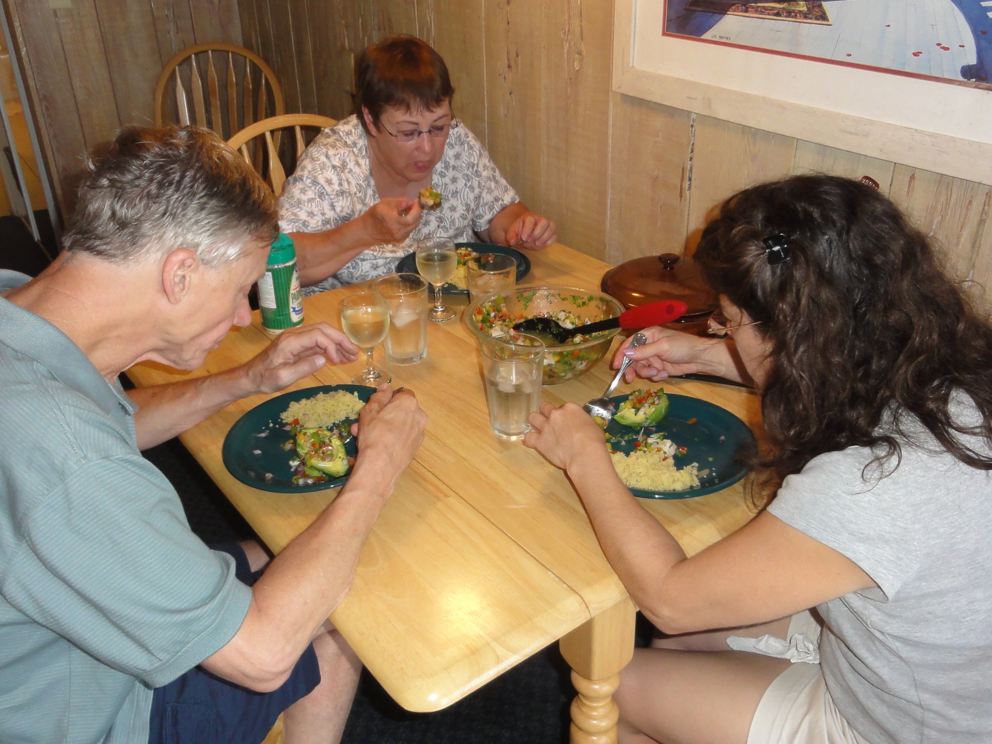 two women and a man are enjoying a meal at the table