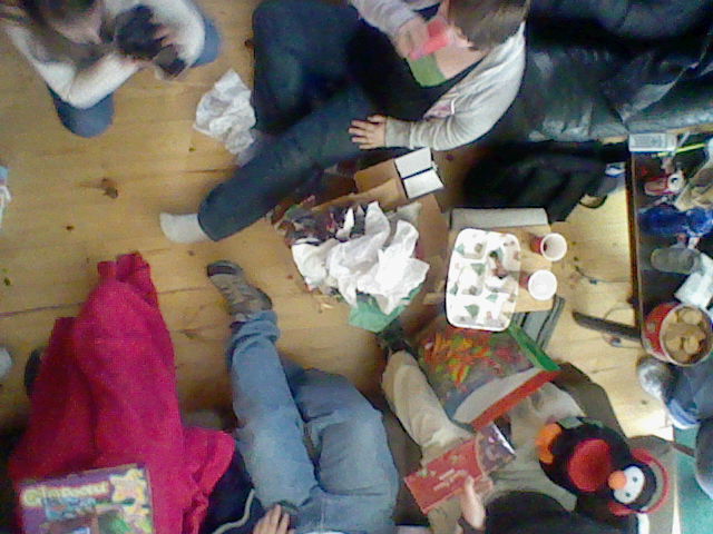 three people eating cake on a wooden floor