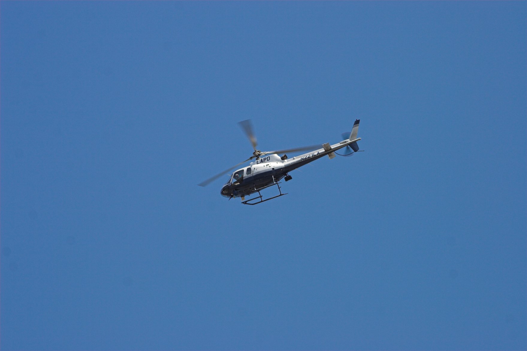 a helicopter flying in the blue sky with no people