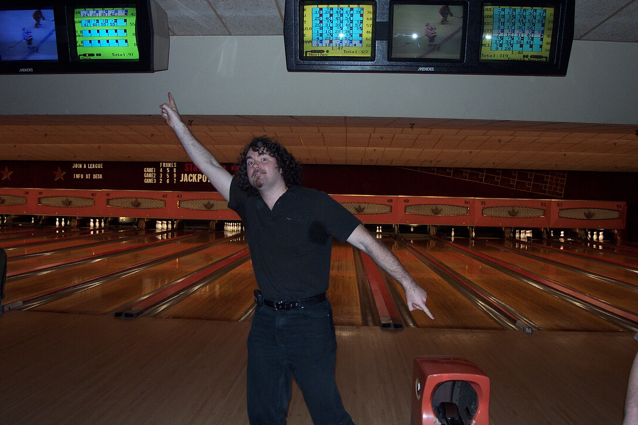 a man in a bowling alley throwing a ball