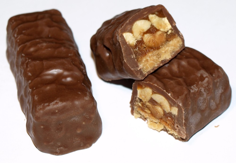 three pieces of chocolate covered fruit and peanut er candy