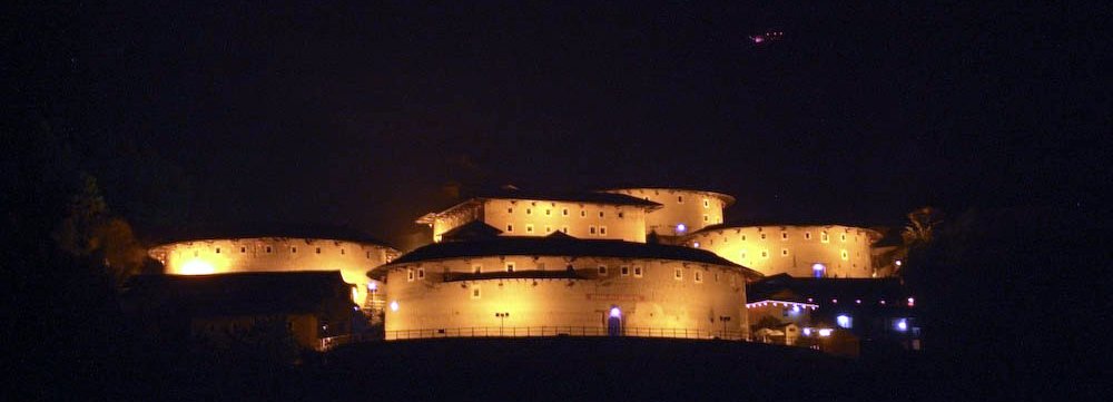 an illuminated castle on top of a hill