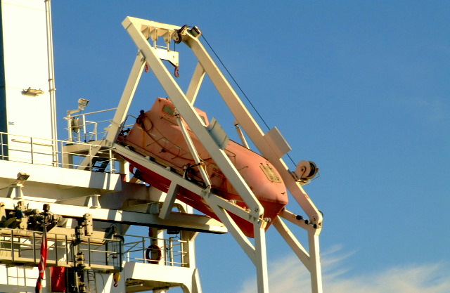 a ship crane is in place to carry a piece of equipment