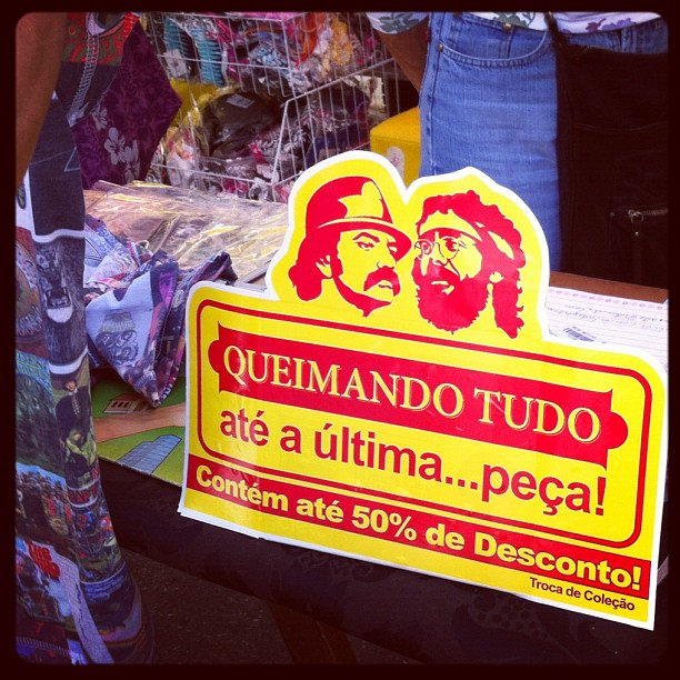 sign about the sale of quilamanoo's on display in front of people at an outdoor market