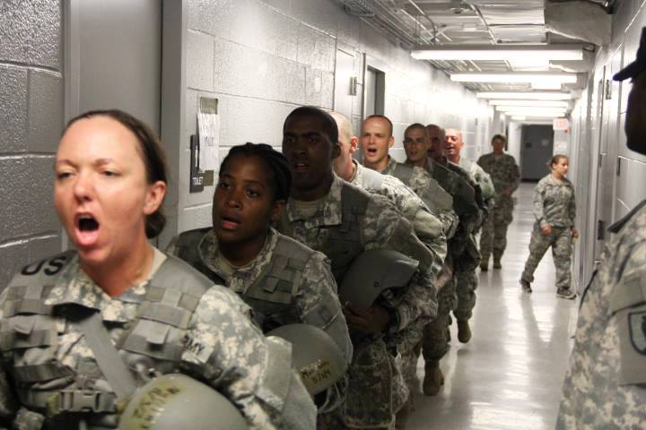 many soldiers are lining the hallway with one person in uniform