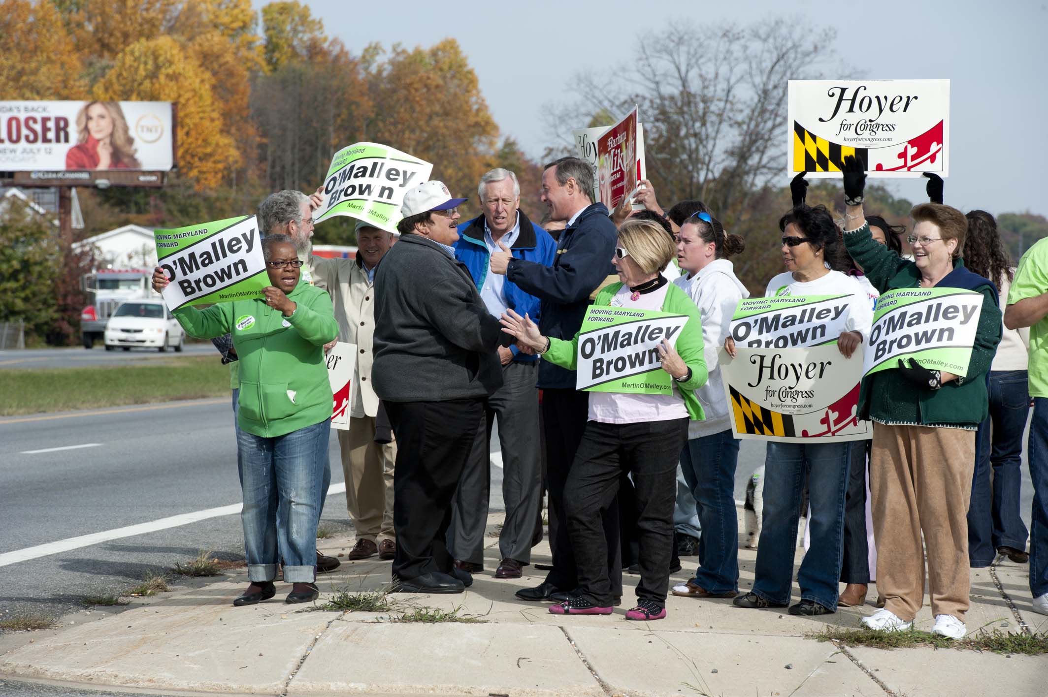 there are several people standing together outside with signs