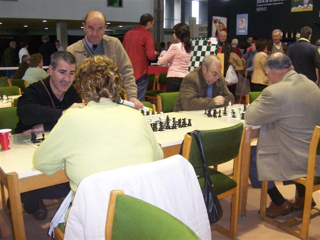 a group of people sitting at tables playing chess