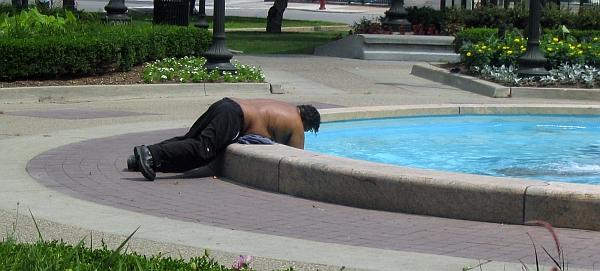 a man is in a fountain, with a dog on his chest