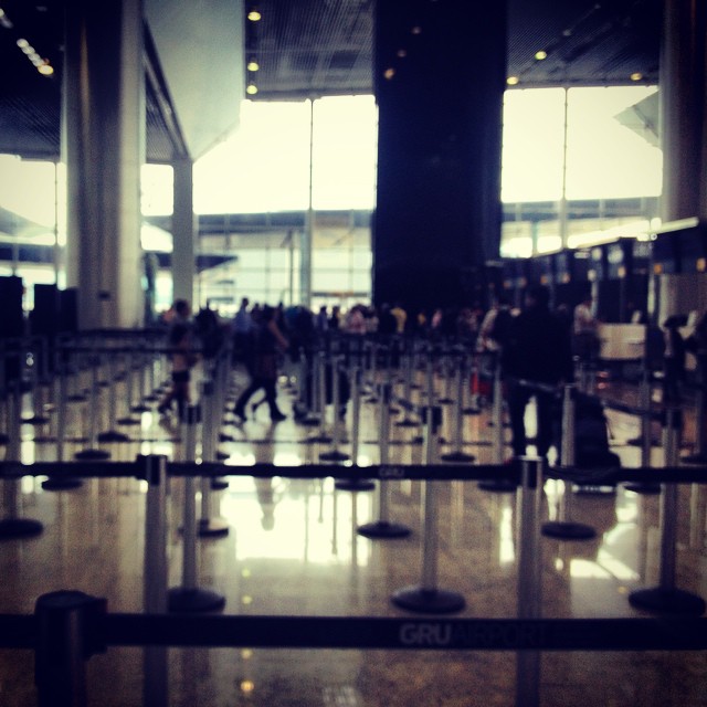 many people walking through an airport near some luggage