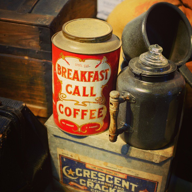 an old fashioned teapot with a cup and kettle sits on top of a chest