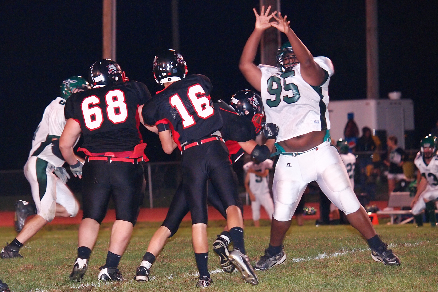 a football player is reaching up to catch a pass