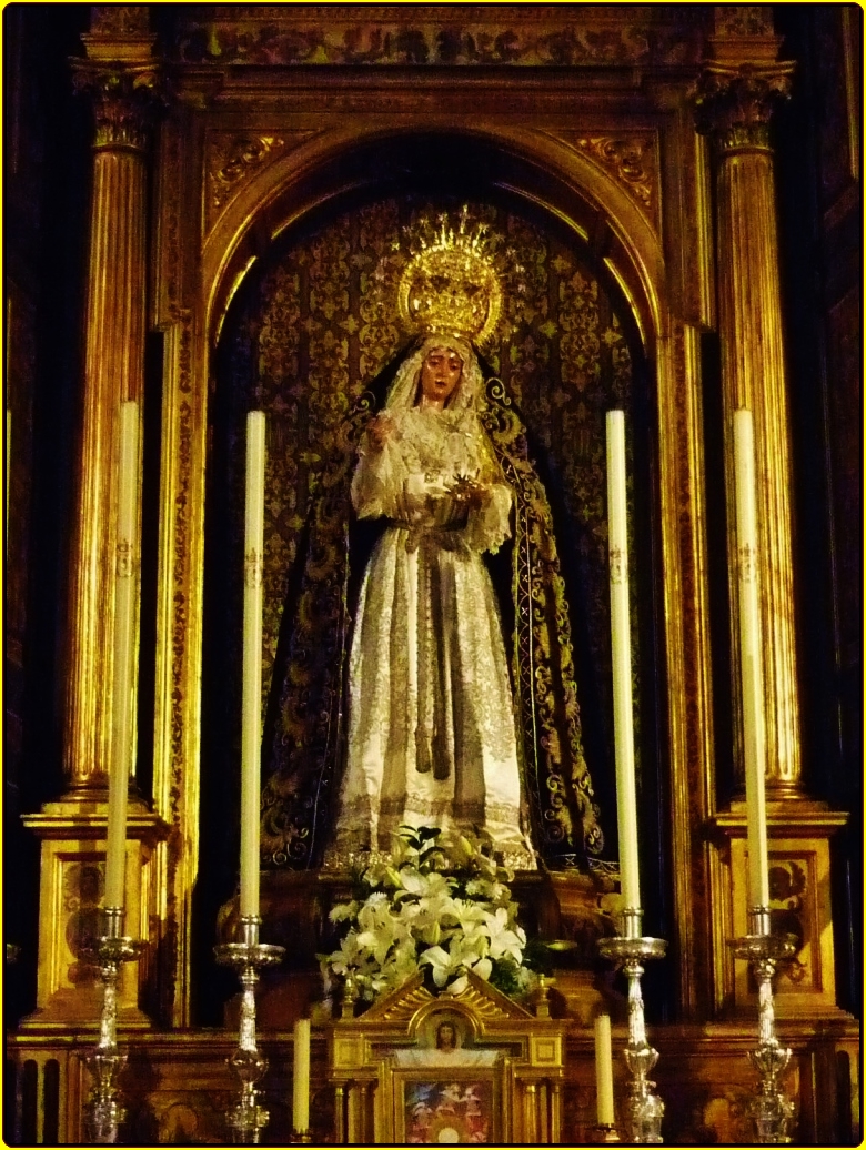 the statue in front of a altar has a yellow background