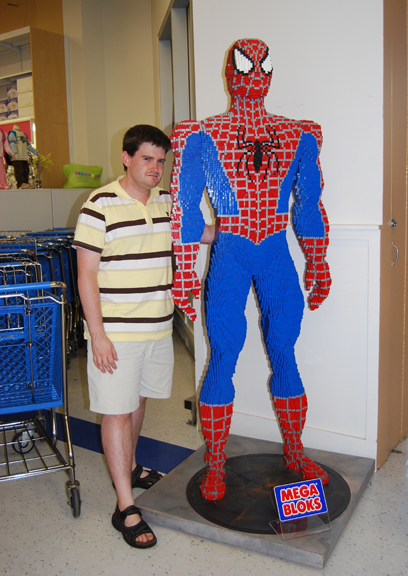 a man stands next to his lego spider - man costume