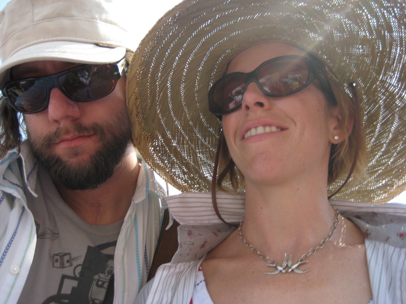 two people in hats and sun glasses posing for a po