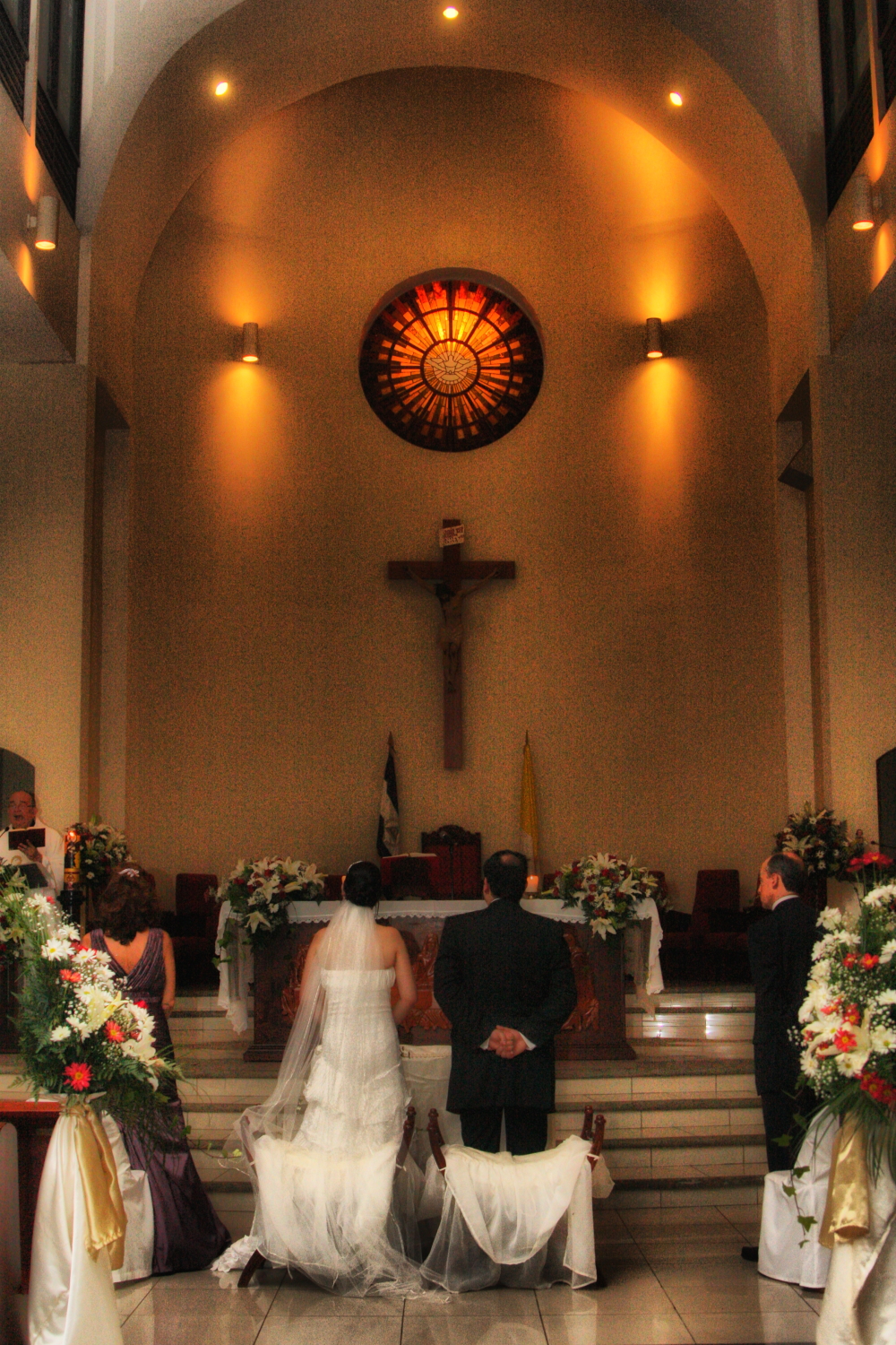 a couple kneeling down at the alter during their wedding ceremony