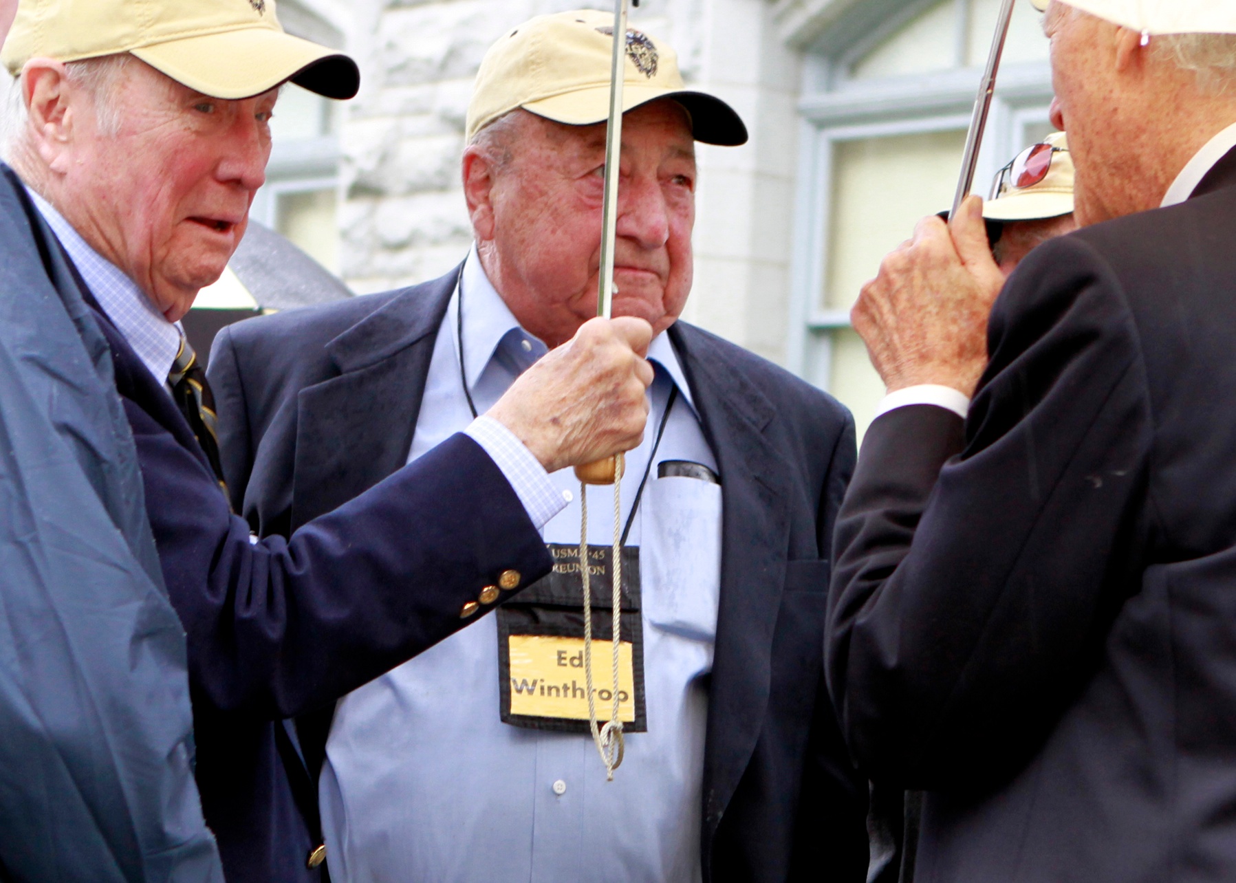 an image of three men talking with two men standing