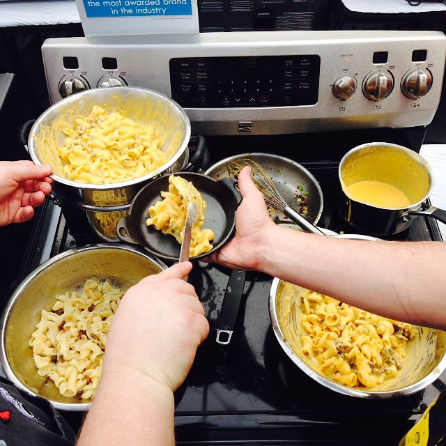 there are two people and a stove cooking pasta