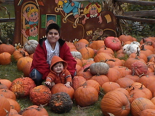 a mother and daughter in a pumpkin patch