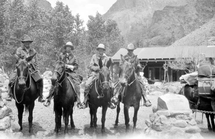a vintage po of cowboys on horseback are standing around