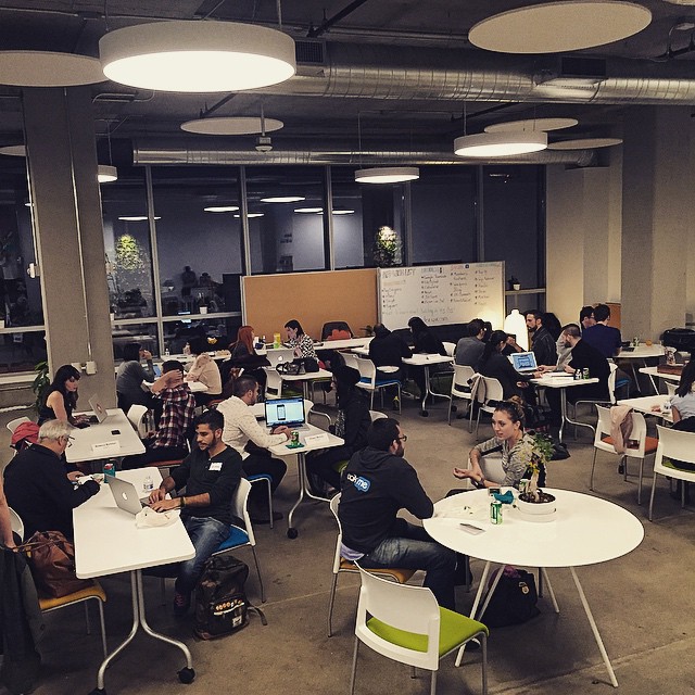 a room filled with people sitting at round tables