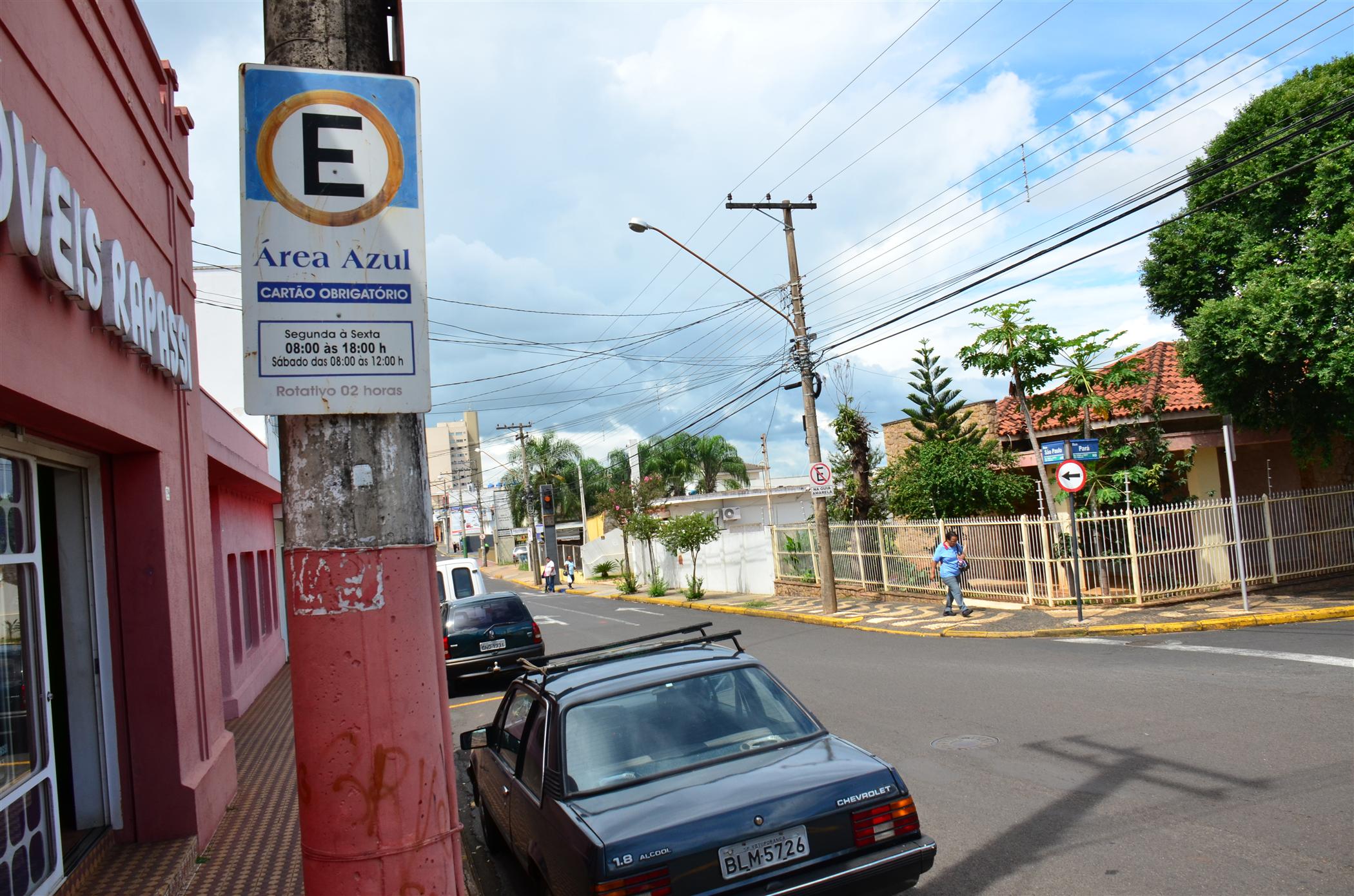 the sign for an es grocery is above two cars parked outside