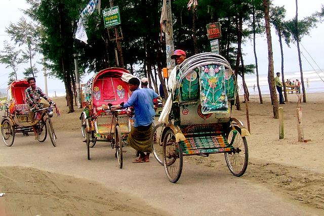 two rickshaws and a man riding in a horse drawn carriage