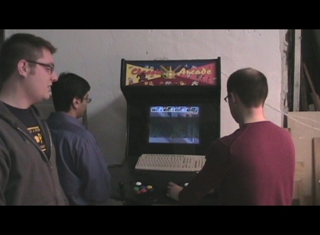 four young people looking at a vintage video game