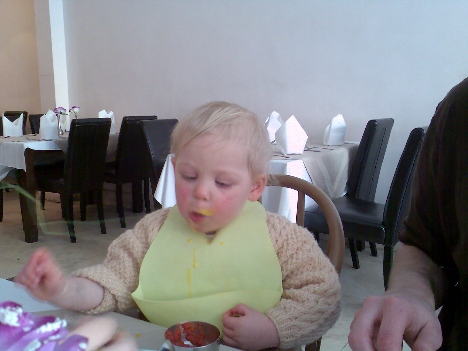 a little child eating food on a plate