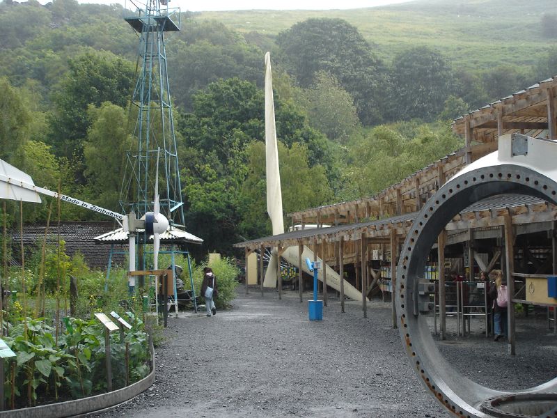 an abandoned building is shown with a giant pipe in front