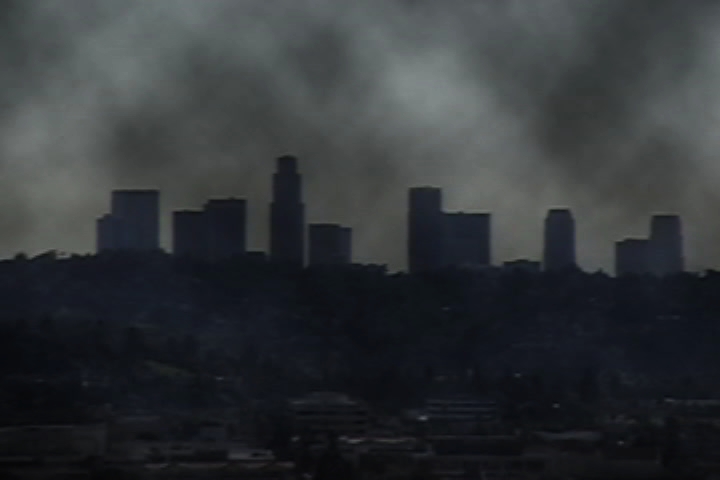 smoke emitting out from some dark skies in a city