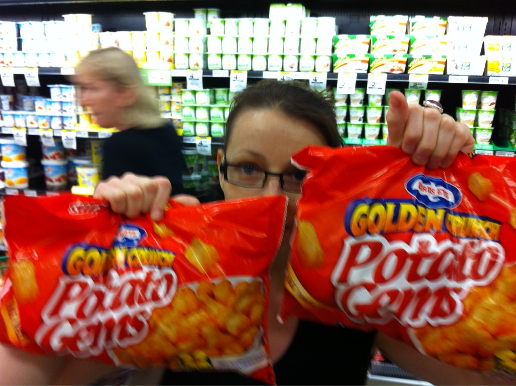 there are two women holding bags of chips in a store