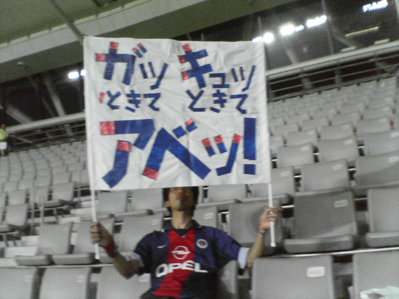 a person sitting on a bench holding a sign with a language that say