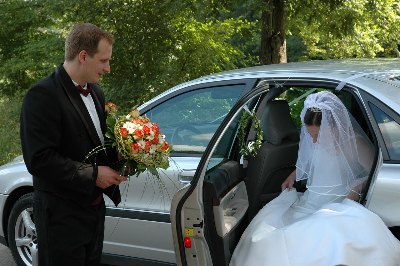 a man in a suit and tie is standing next to a wedding dress