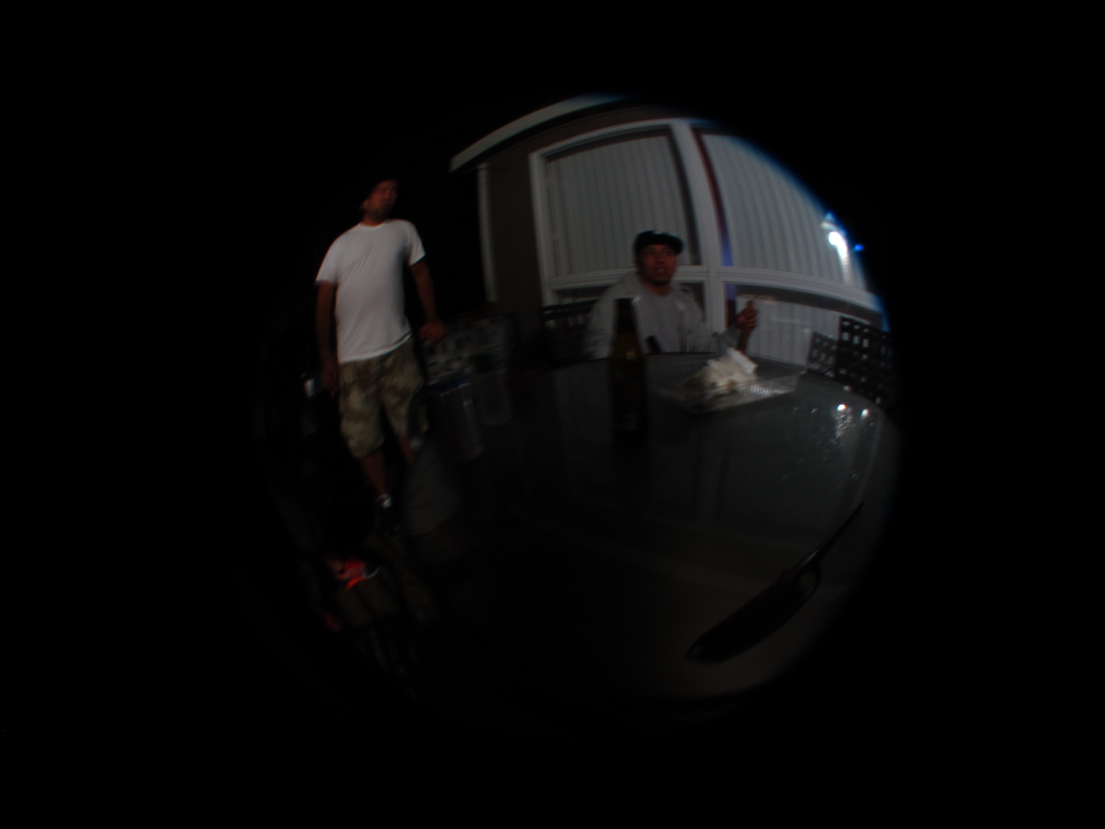 two guys in the background are seen through a round mirror