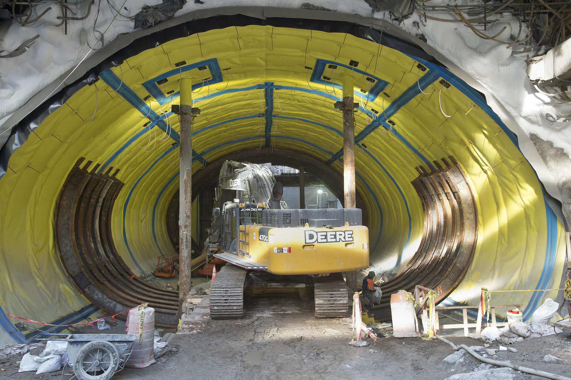 people work inside an industrial tunnel holding equipment